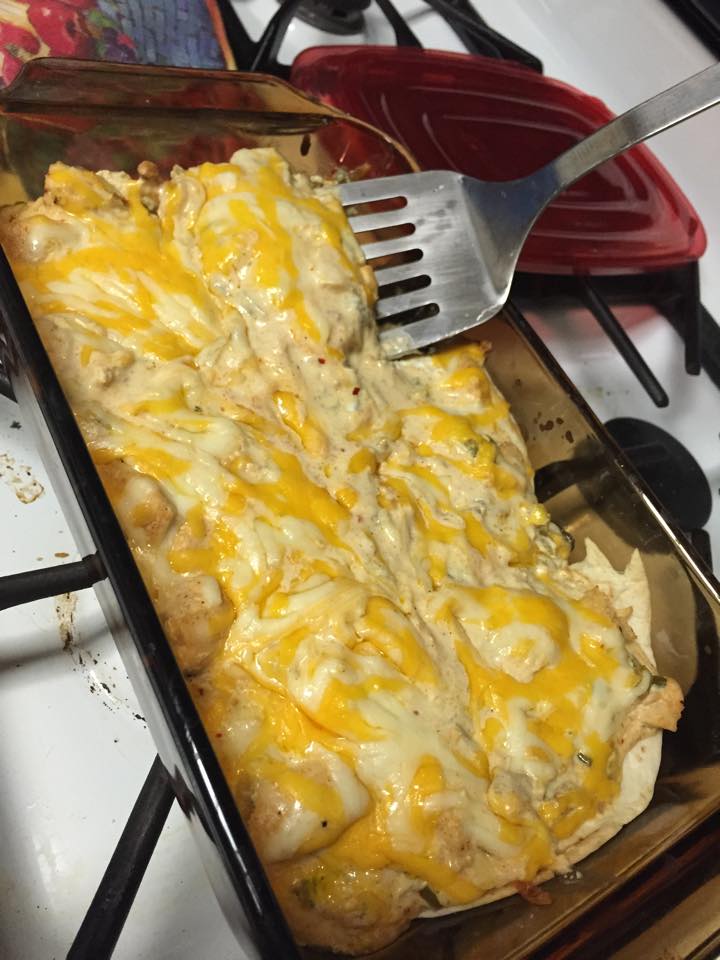 Close-up of a cheesy baked casserole dish with melted yellow and white cheese being served with a spatula — an unexpected visual metaphor for blending disciplines in innovation