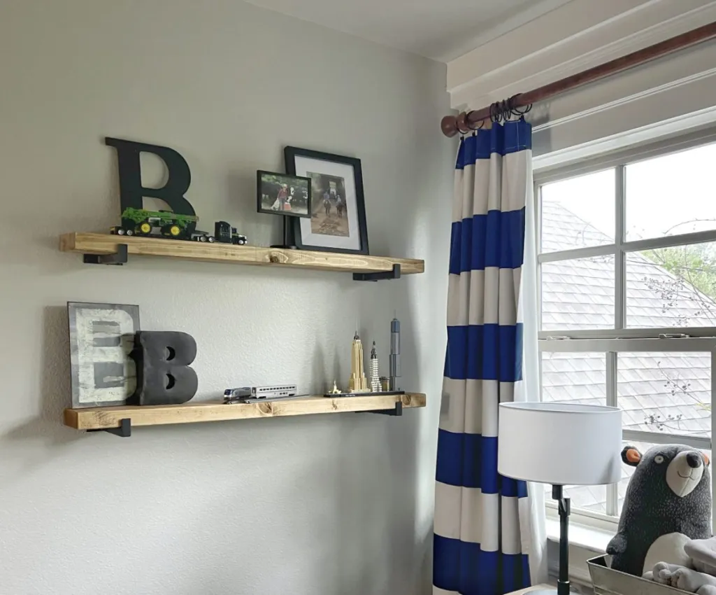 Interior room corner with wooden wall shelves holding decorative letters and small figurines, warm and cozy